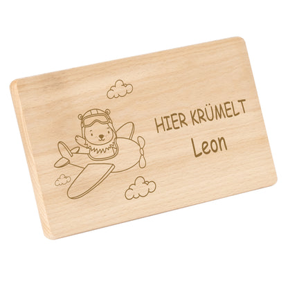 Frühstücksbrettchen 220x120mm mit Gravur "HIER KRÜMELT" Flugzeug mit Löwe und Wunschname